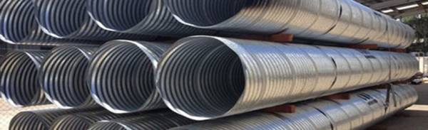 Lock-seamed corrugated metal pipes are neatly stored in the warehouse.