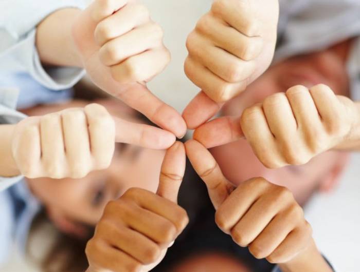 Six team members thumb up.